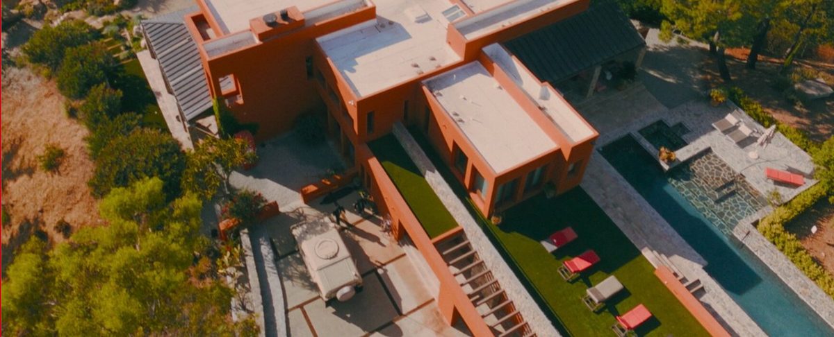 Aerial view of the terracotta safe house, its pool and lawn