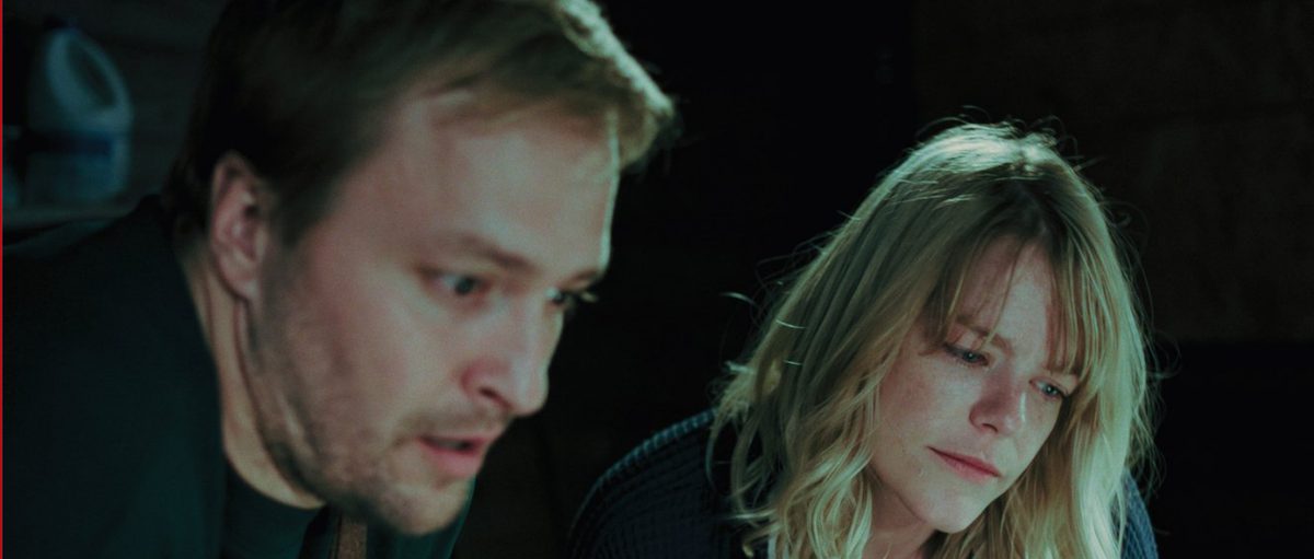 Vince and Claire lit by a laptop in the dark
