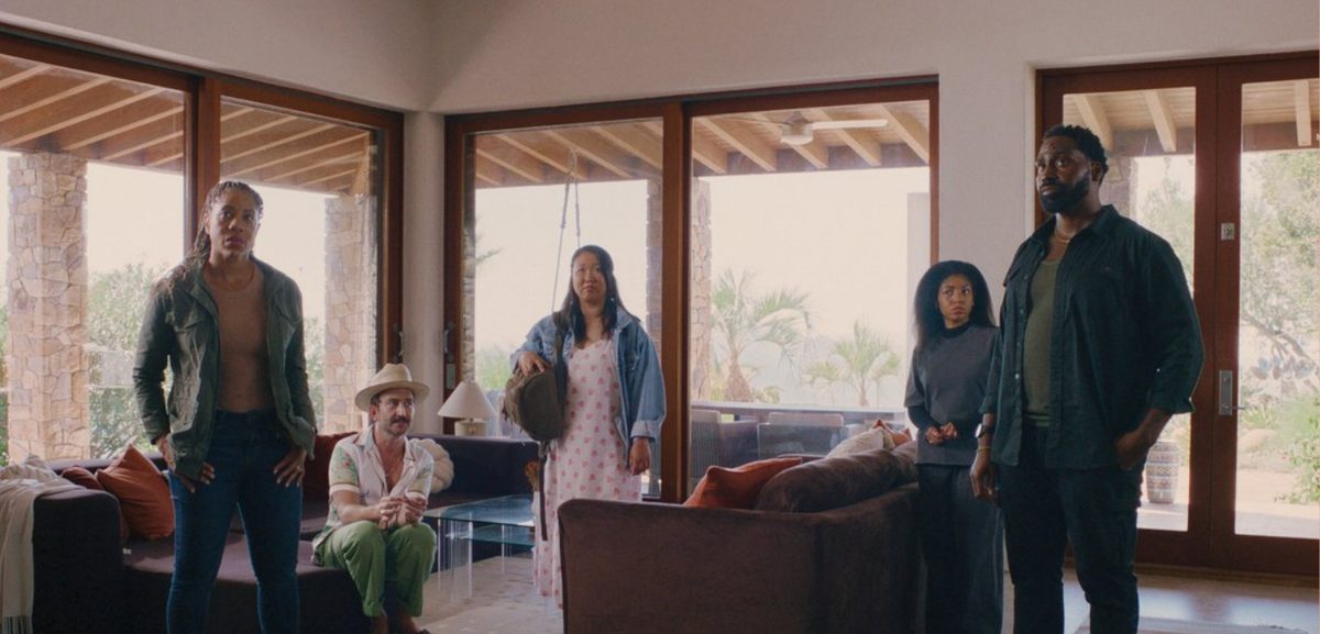 The escapees stand uneasily in the sunlit living room of the safe house
