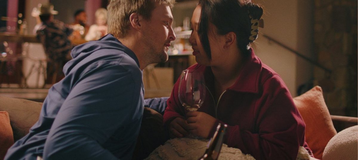 Vince and Zoey lean close over a glass of wine